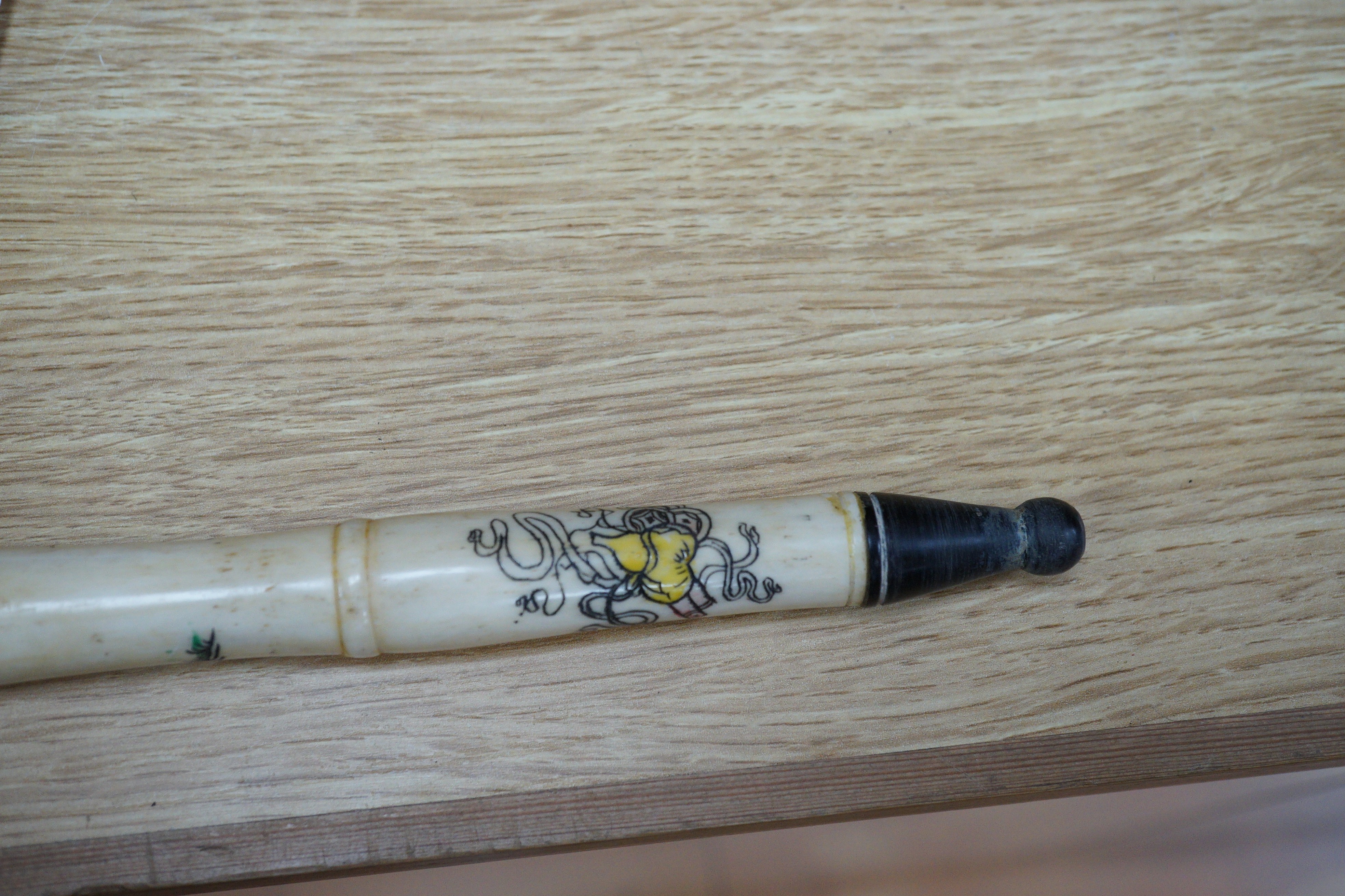 A south East Asian engraved bone and a carved ebony walking cane